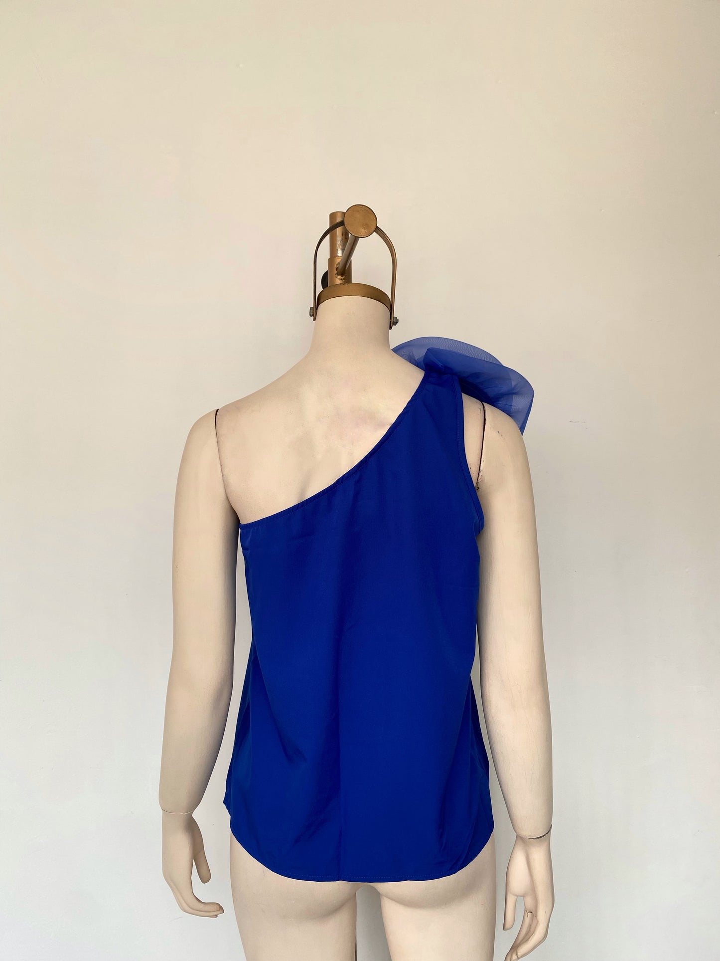 Blusa asimétrica con detalle de rosa